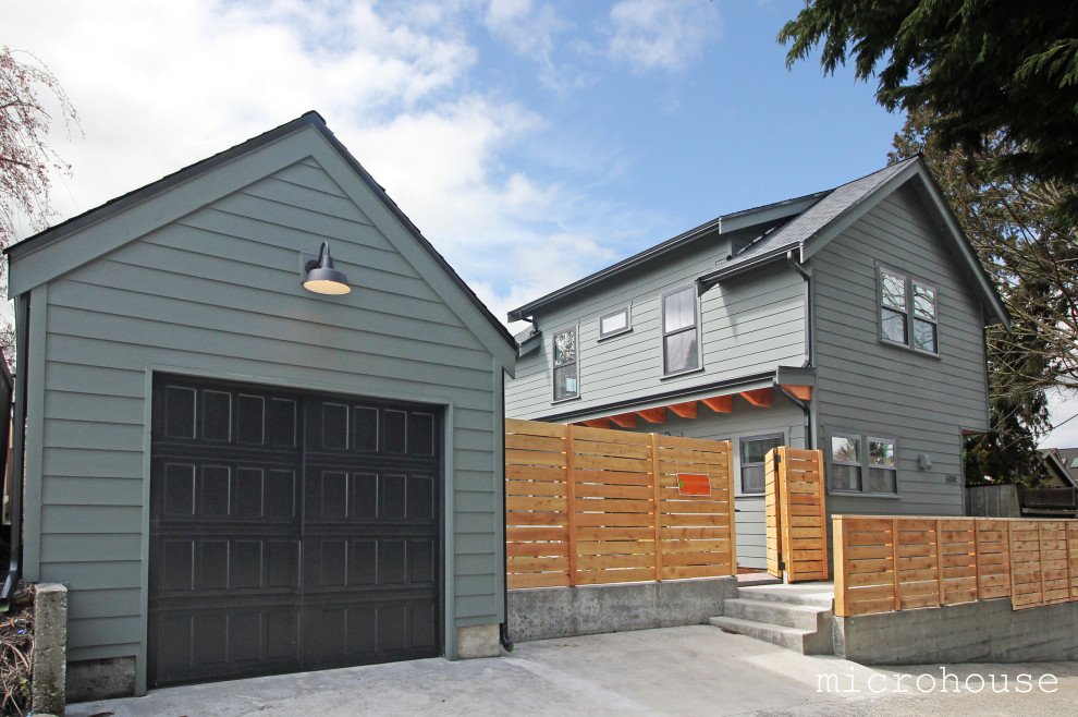 Amerikansk inredning av ett litet grönt hus, med två våningar, fiberplattor i betong, sadeltak och tak i shingel