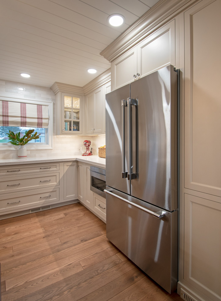 Kitchen - transitional shiplap ceiling, medium tone wood floor and brown floor kitchen idea with shaker cabinets, beige cabinets, quartz countertops, white backsplash, stainless steel appliances, white countertops and cement tile backsplash
