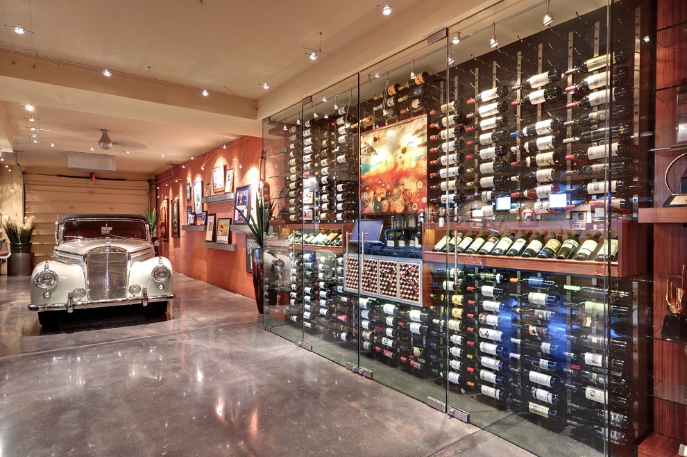 This is an example of a mid-sized contemporary wine cellar in Phoenix with concrete floors, display racks and grey floor.