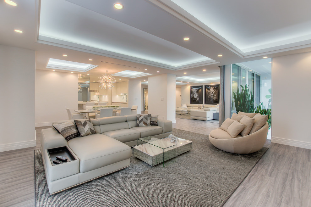 Photo of an expansive contemporary open concept family room in Los Angeles with vinyl floors and beige walls.