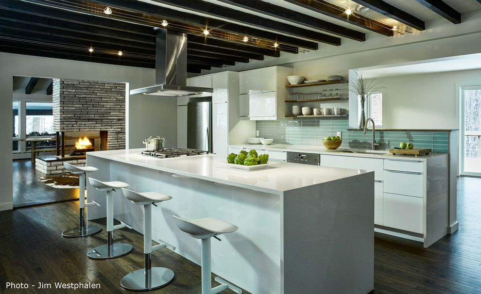 Inspiration for a mid-sized contemporary galley eat-in kitchen in Other with an undermount sink, flat-panel cabinets, white cabinets, solid surface benchtops, blue splashback, glass tile splashback, stainless steel appliances, dark hardwood floors and with island.