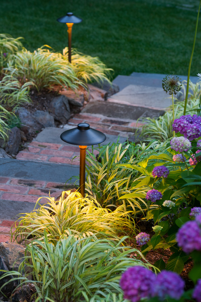 Design ideas for an expansive traditional sloped partial sun garden for summer in New York with brick pavers.