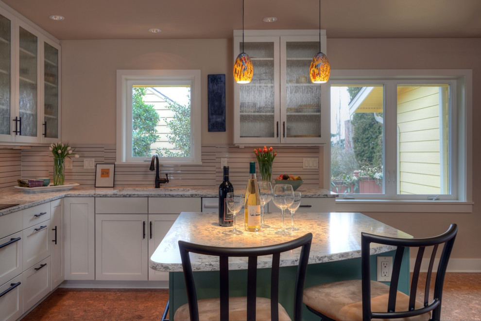 Inspiration for a mid-sized arts and crafts l-shaped eat-in kitchen in Seattle with shaker cabinets, white cabinets, white appliances, cork floors, with island, quartzite benchtops, beige splashback, glass tile splashback, an undermount sink and brown floor.