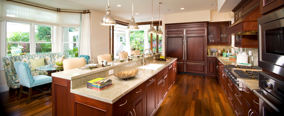 Photo of a large tropical l-shaped eat-in kitchen in Hawaii with a double-bowl sink, raised-panel cabinets, medium wood cabinets, granite benchtops, stainless steel appliances, dark hardwood floors and with island.
