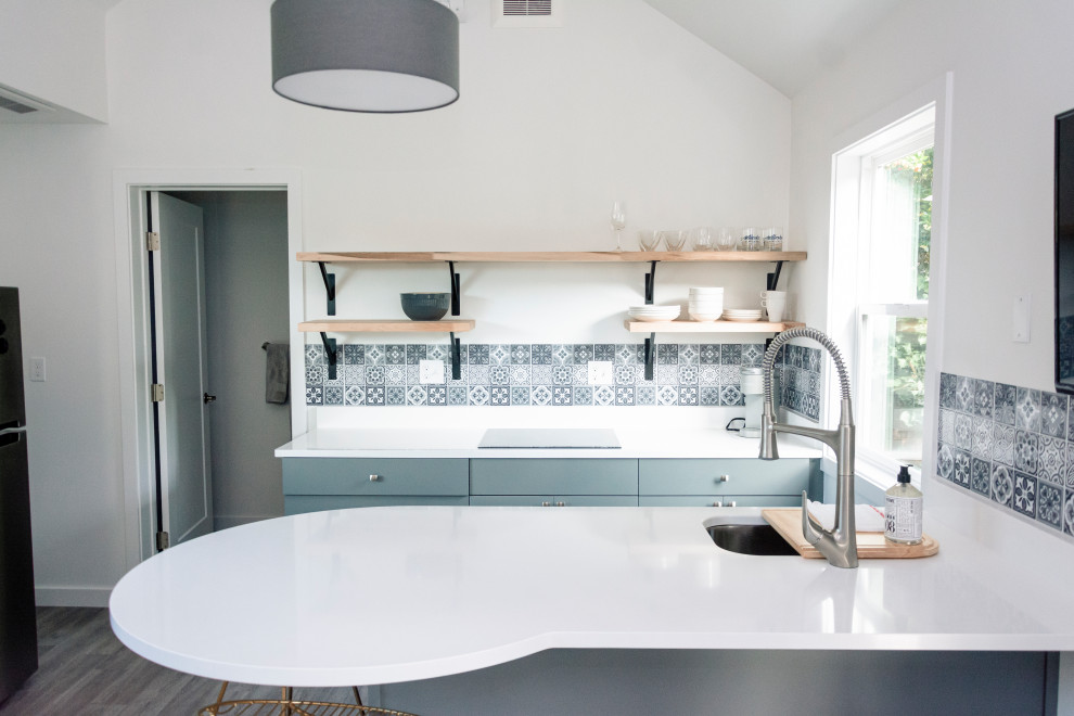 Design ideas for a small traditional u-shaped eat-in kitchen in Seattle with an undermount sink, blue splashback, a peninsula, white benchtop and vaulted.
