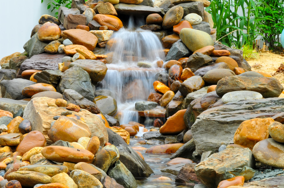 Mountain style backyard stone and rectangular lap pool fountain photo in Baltimore