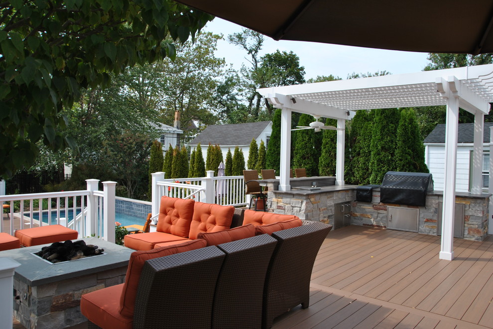 Design ideas for a small traditional backyard deck in New York with a fire feature and a pergola.