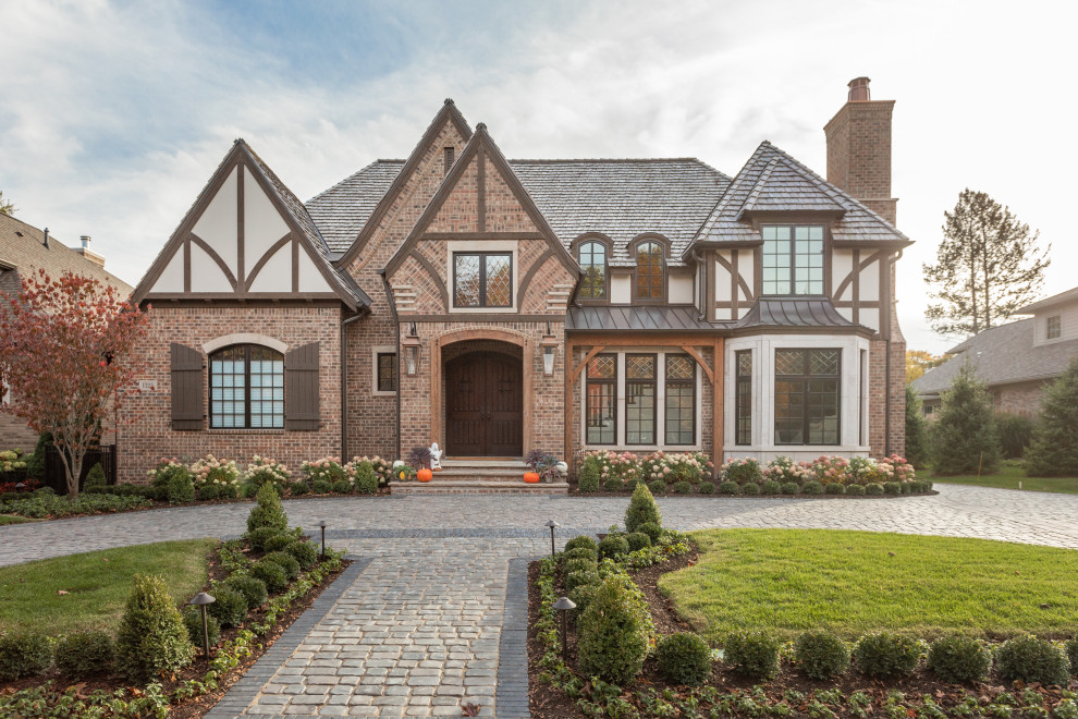 Expansive traditional two-storey brick beige house exterior in Detroit with a hip roof and a shingle roof.