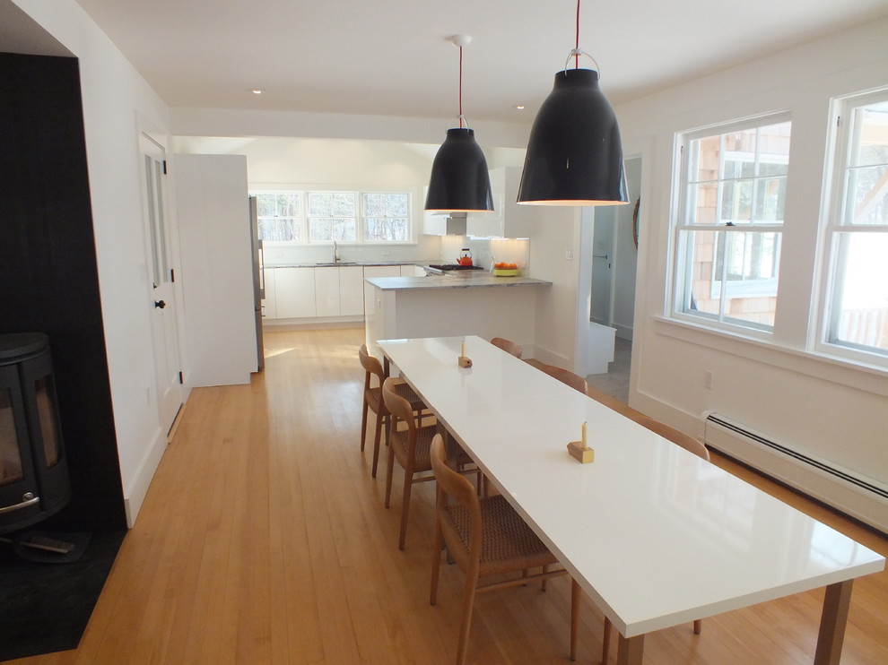 Photo of a mid-sized scandinavian kitchen/dining combo in Boston with white walls, light hardwood floors and no fireplace.