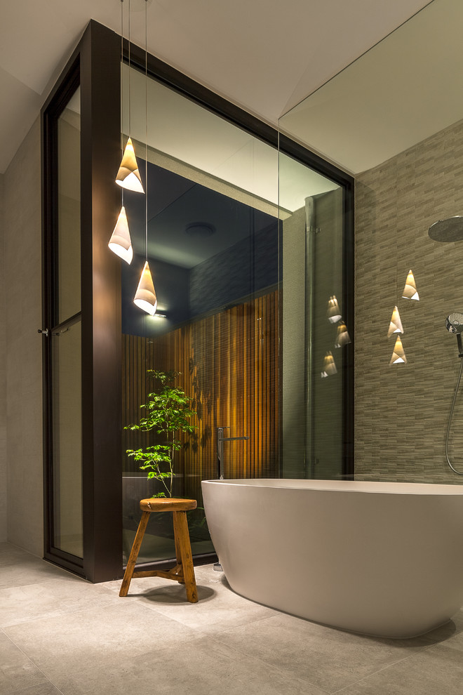 This is an example of a modern master bathroom in Melbourne with a freestanding tub, beige tile, slate, slate floors, granite benchtops and grey floor.