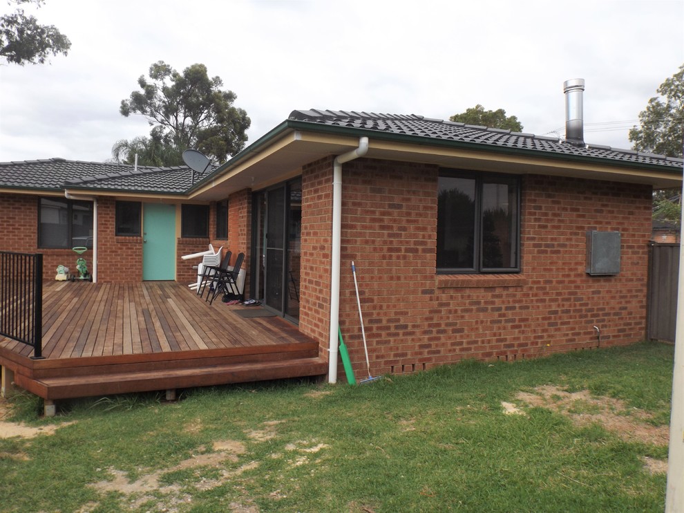 This is an example of a mid-sized modern one-storey brick red exterior in Sydney with a hip roof.
