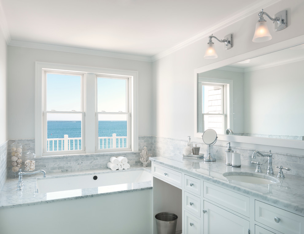Beach style bathroom in Providence with an undermount sink, recessed-panel cabinets, white cabinets and an undermount tub.