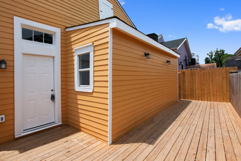 Design ideas for a mid-sized eclectic one-storey yellow exterior in New Orleans with wood siding.