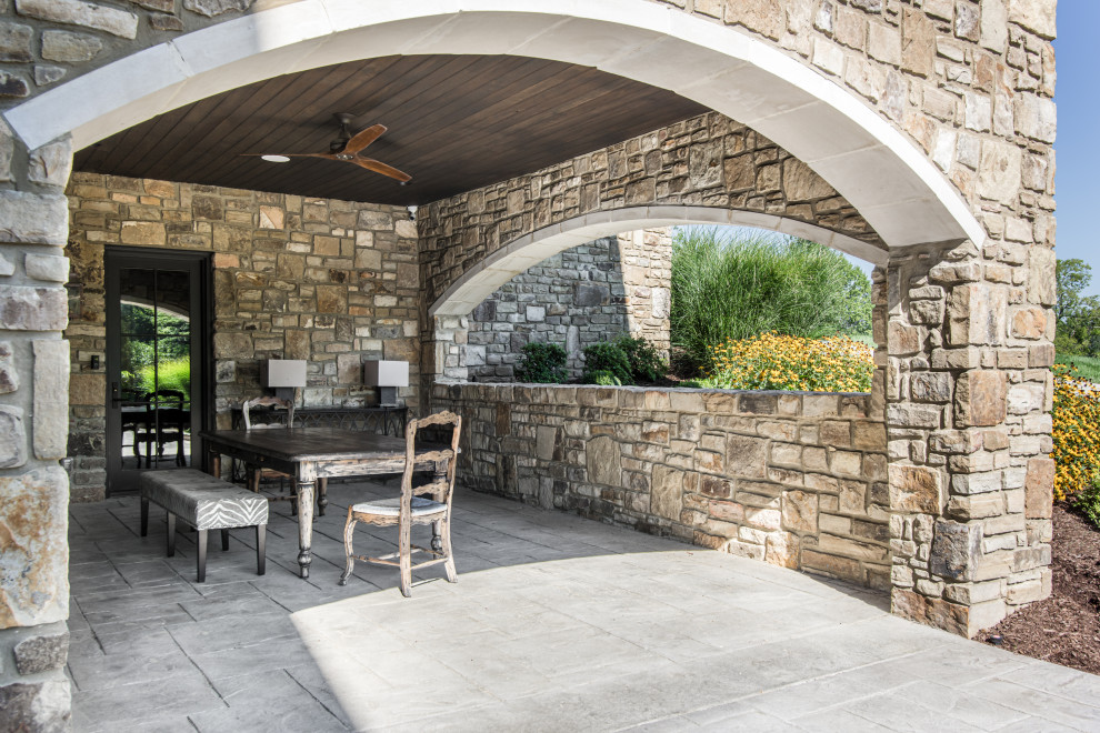 Huge transitional stone front porch idea in Nashville with a roof extension