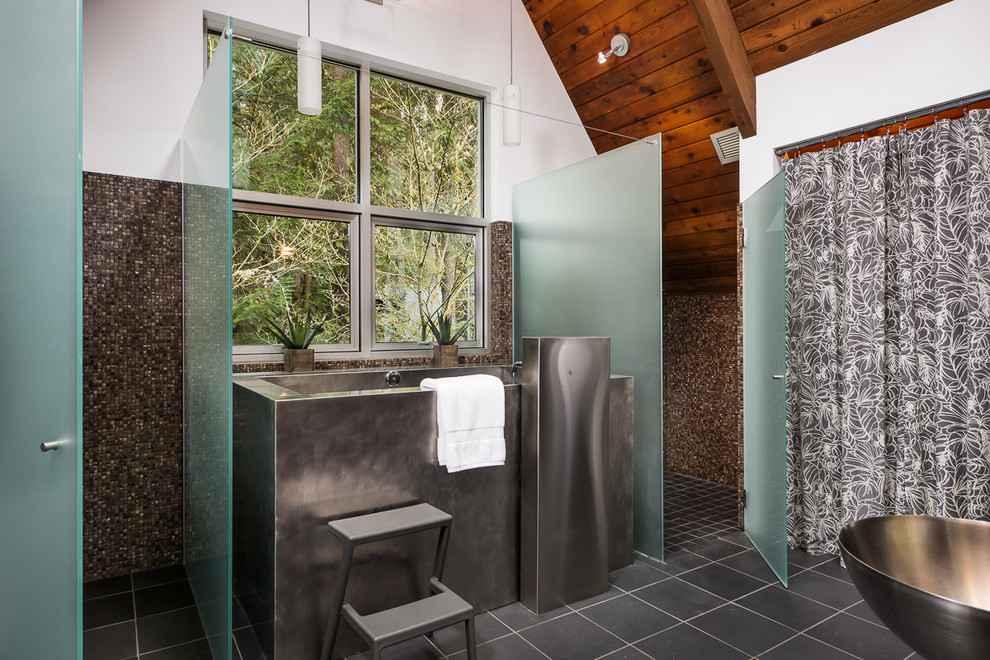 This is an example of a mid-sized industrial master bathroom in Seattle with a japanese tub, a curbless shower, a wall-mount toilet, brown tile, mosaic tile, brown walls, slate floors and a wall-mount sink.