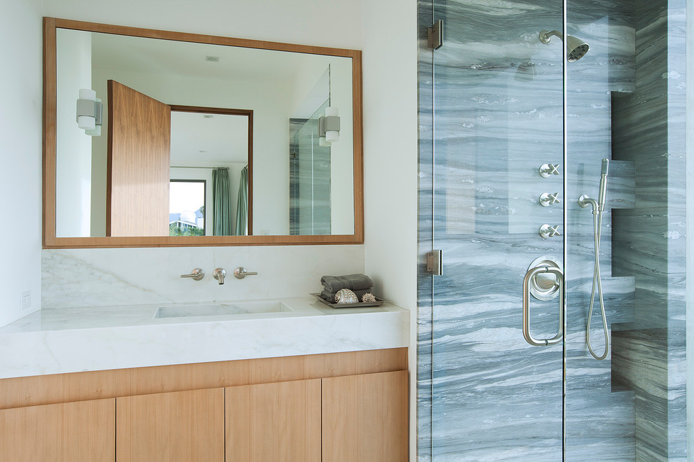 Large beach style master bathroom in Los Angeles with flat-panel cabinets, white cabinets, a freestanding tub, an alcove shower, a one-piece toilet, gray tile, cement tile, grey walls, limestone floors, a console sink, granite benchtops, beige floor, a hinged shower door and white benchtops.