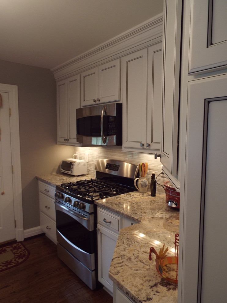Photo of a traditional eat-in kitchen in Louisville with an undermount sink, flat-panel cabinets, white cabinets, granite benchtops and stainless steel appliances.