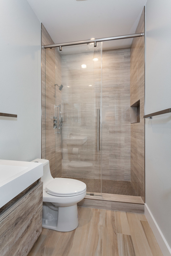 Photo of a small contemporary 3/4 bathroom in Los Angeles with flat-panel cabinets, light wood cabinets, an alcove shower, a one-piece toilet, brown tile, ceramic tile, brown walls, mosaic tile floors, a drop-in sink, quartzite benchtops, brown floor, a sliding shower screen and white benchtops.