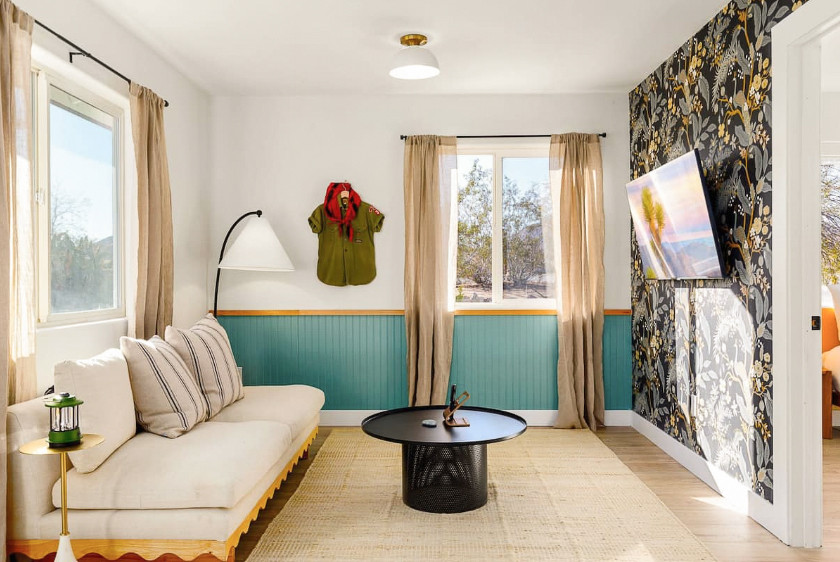 Cette photo montre un salon moderne avec un mur multicolore, parquet clair, un téléviseur fixé au mur, un sol marron et boiseries.