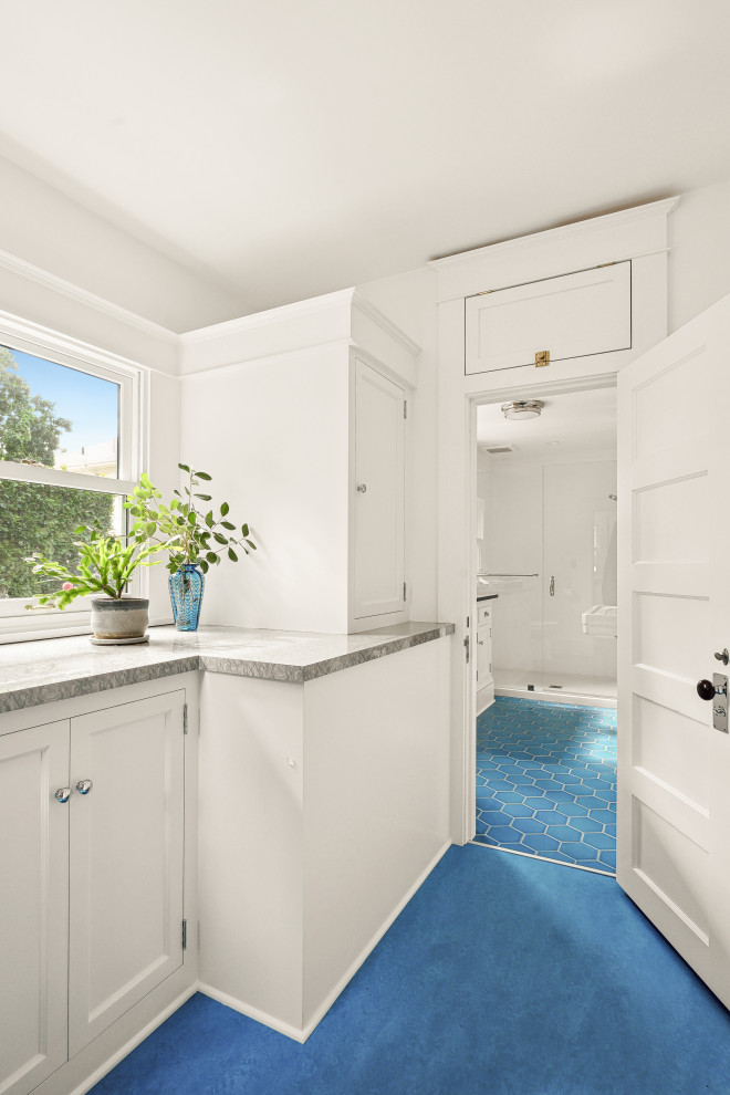 Идея дизайна: главная ванная комната среднего размера в классическом стиле с фасадами с утопленной филенкой, белыми фасадами, душем без бортиков, унитазом-моноблоком, белой плиткой, плиткой из листового камня, белыми стенами, полом из керамической плитки, раковиной с пьедесталом, столешницей из гранита, синим полом, душем с распашными дверями, серой столешницей, нишей, тумбой под одну раковину и напольной тумбой