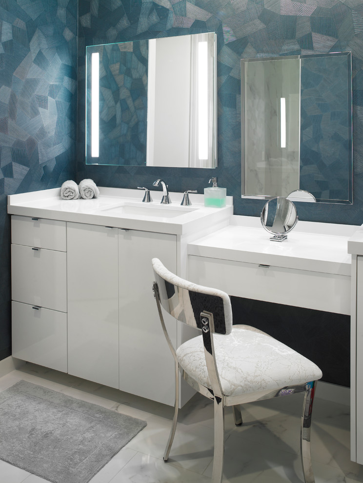 Photo of a mid-sized modern bathroom in Miami with flat-panel cabinets, white cabinets, multi-coloured walls, an undermount sink, solid surface benchtops, beige floor, beige benchtops, a one-piece toilet and marble floors.