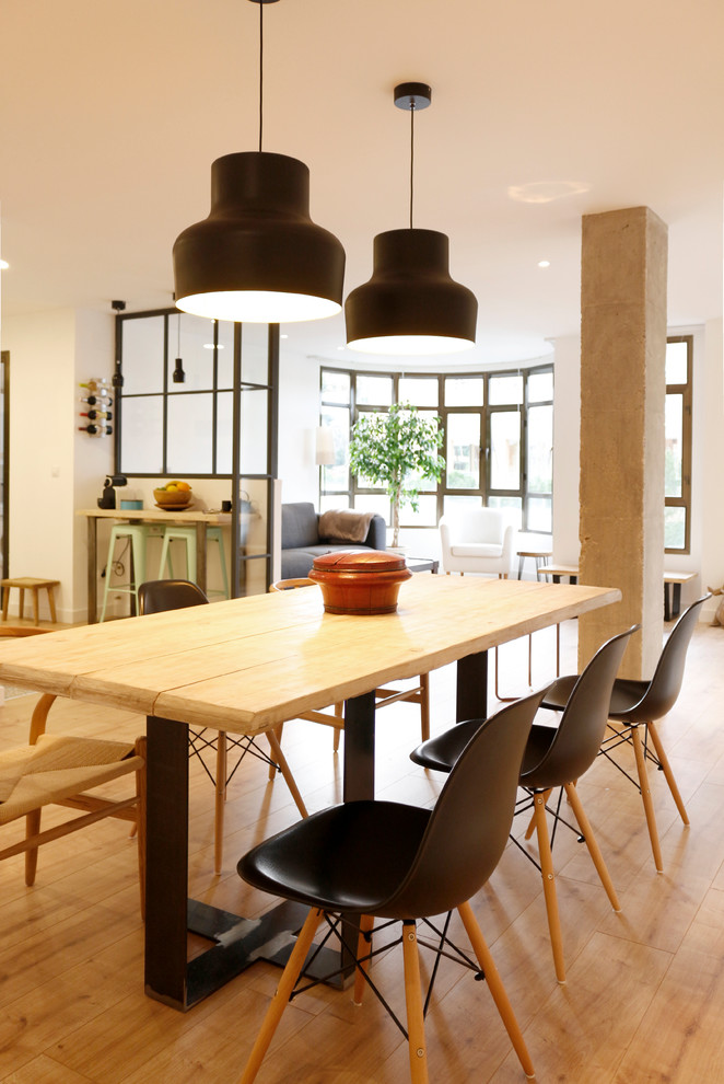 Photo of a large industrial open plan dining in Madrid with white walls, medium hardwood floors and no fireplace.