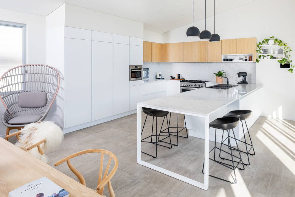 Inspiration for a mid-sized contemporary u-shaped eat-in kitchen in Perth with a double-bowl sink, flat-panel cabinets, marble benchtops, grey splashback, ceramic splashback, stainless steel appliances, multiple islands, brown floor and white benchtop.