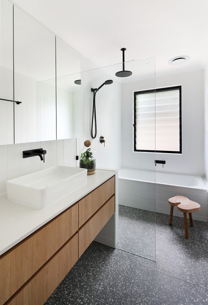 Contemporary bathroom in Perth with flat-panel cabinets, medium wood cabinets, a vessel sink, black floor and white benchtops.