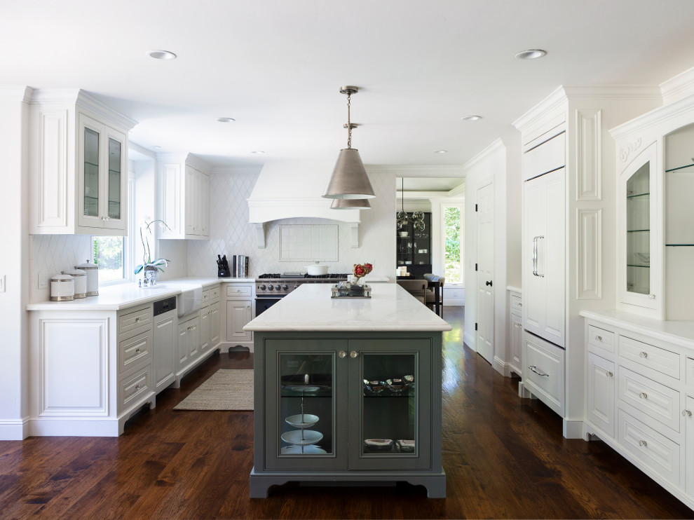 Design ideas for a transitional u-shaped kitchen in San Francisco with a farmhouse sink, raised-panel cabinets, white cabinets, white splashback, panelled appliances, medium hardwood floors, brown floor and white benchtop.