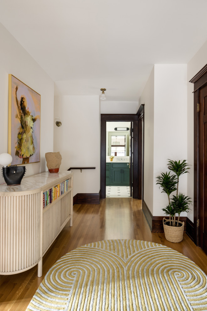 Idées déco pour un couloir craftsman de taille moyenne avec un mur blanc et un sol en bois brun.