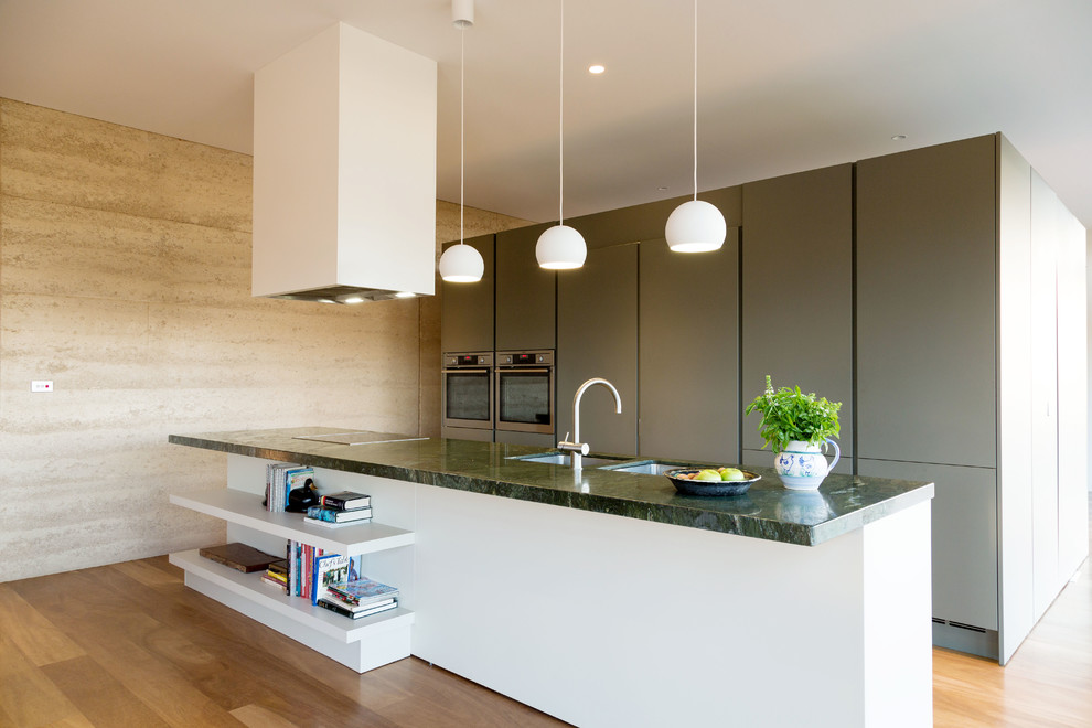 Photo of a mid-sized contemporary galley kitchen in Melbourne with flat-panel cabinets, grey cabinets, marble benchtops, stainless steel appliances and light hardwood floors.