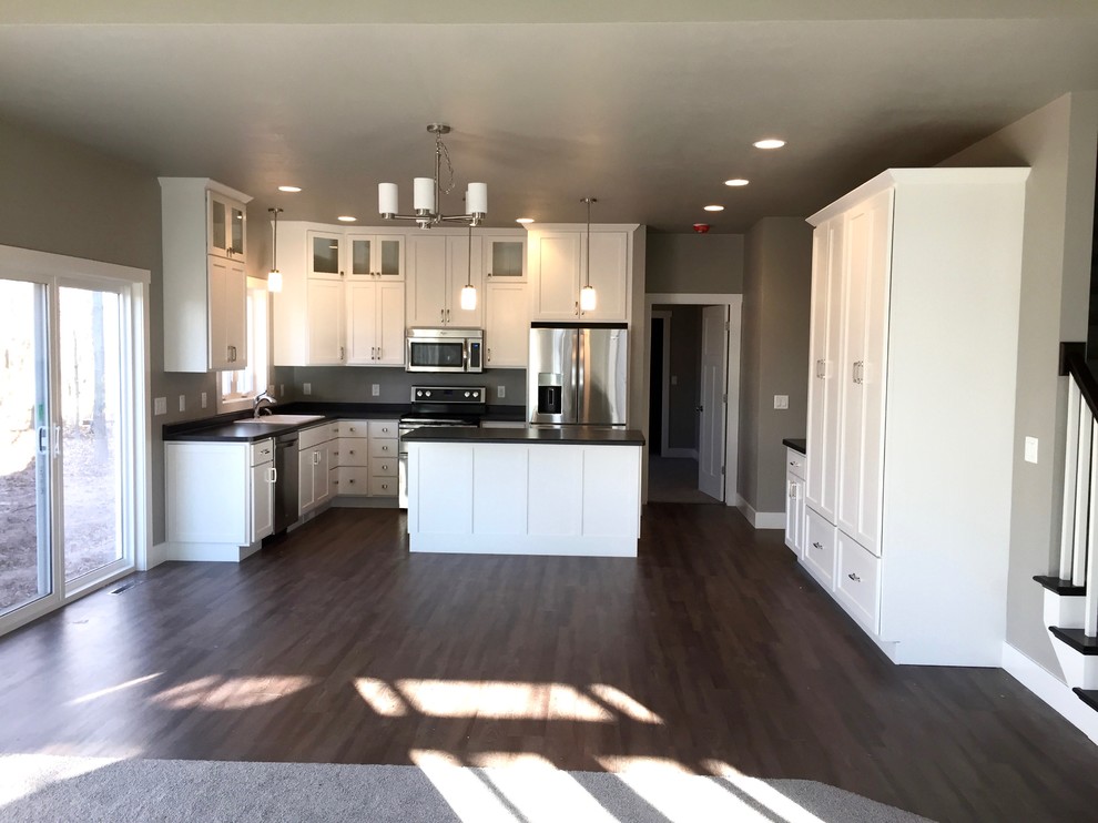 Mid-sized arts and crafts u-shaped eat-in kitchen in Other with a drop-in sink, shaker cabinets, white cabinets, laminate benchtops, stainless steel appliances, vinyl floors and with island.
