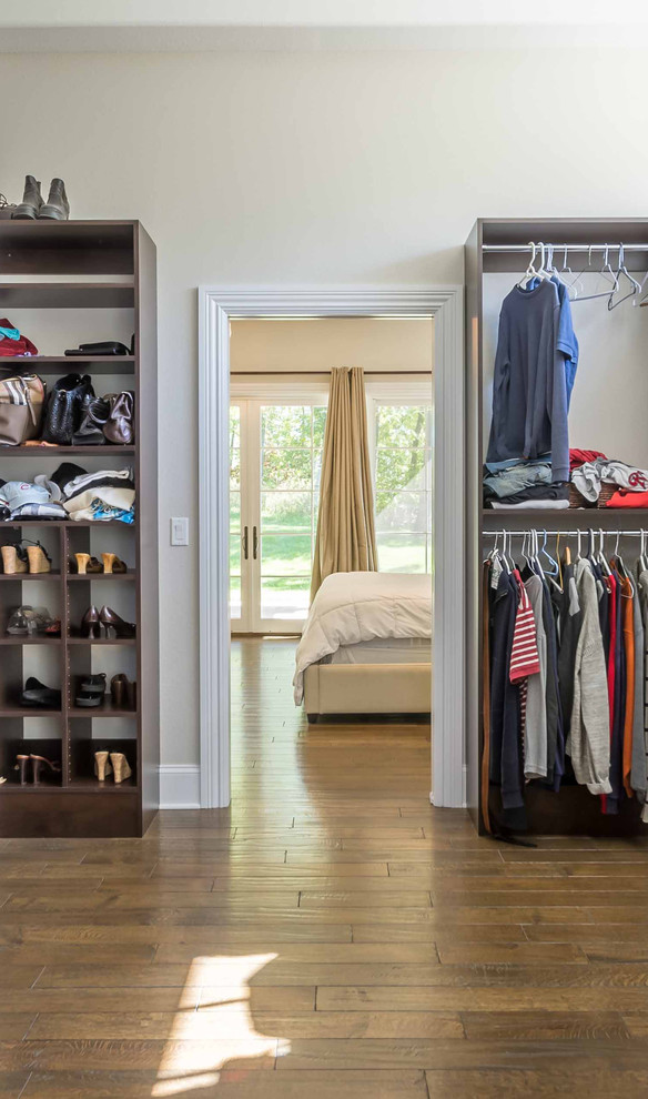 Mid-sized transitional gender-neutral walk-in wardrobe in Chicago with medium hardwood floors, brown floor, open cabinets, dark wood cabinets and recessed.