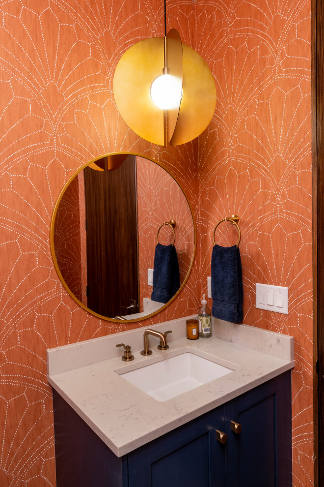 Inspiration pour un petit WC et toilettes vintage avec un placard à porte affleurante, des portes de placard bleues, un mur orange, un lavabo encastré, un plan de toilette en quartz, un plan de toilette beige, meuble-lavabo suspendu et du papier peint.