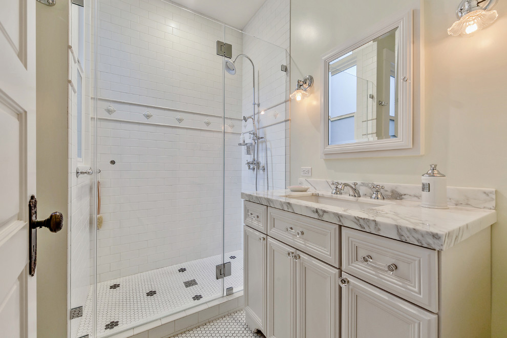 Photo of a small traditional 3/4 bathroom in San Francisco with beaded inset cabinets, white cabinets, an alcove shower, white tile, subway tile, white walls, ceramic floors, an undermount sink, quartzite benchtops, white floor and a hinged shower door.