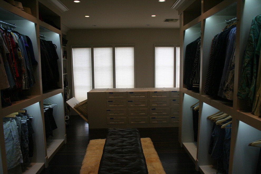 Photo of a large modern gender-neutral walk-in wardrobe in Miami with open cabinets, white cabinets and dark hardwood floors.