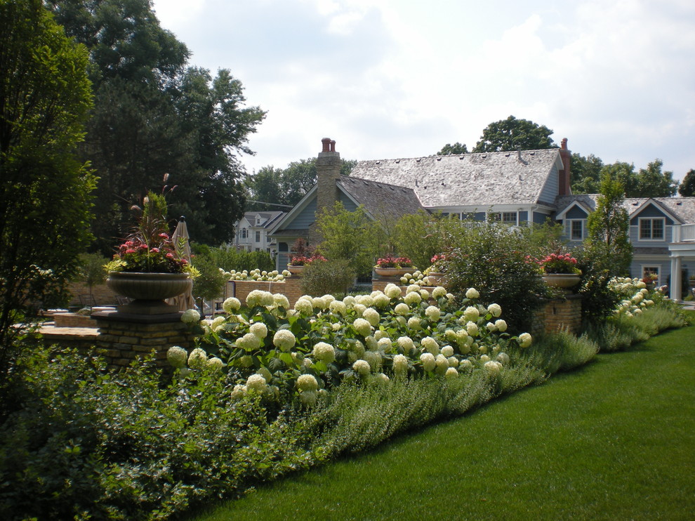 Traditional backyard partial sun garden in Chicago with a container garden for summer.