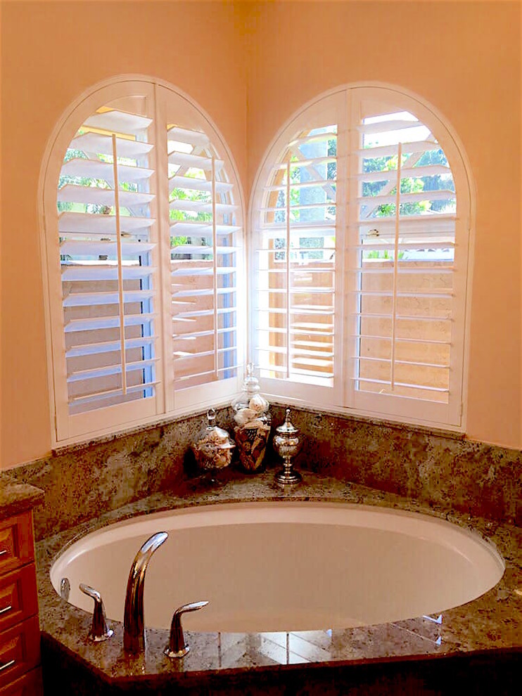 Example of a mid-sized transitional master corner bathtub design in Orange County with beige walls