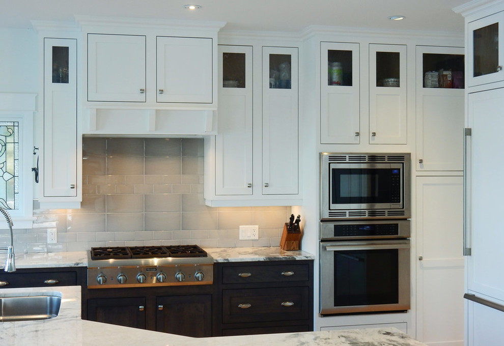 Transitional l-shaped medium tone wood floor and brown floor open concept kitchen photo with an undermount sink, beaded inset cabinets, white cabinets, quartz countertops, gray backsplash, ceramic backsplash, stainless steel appliances, an island and white countertops