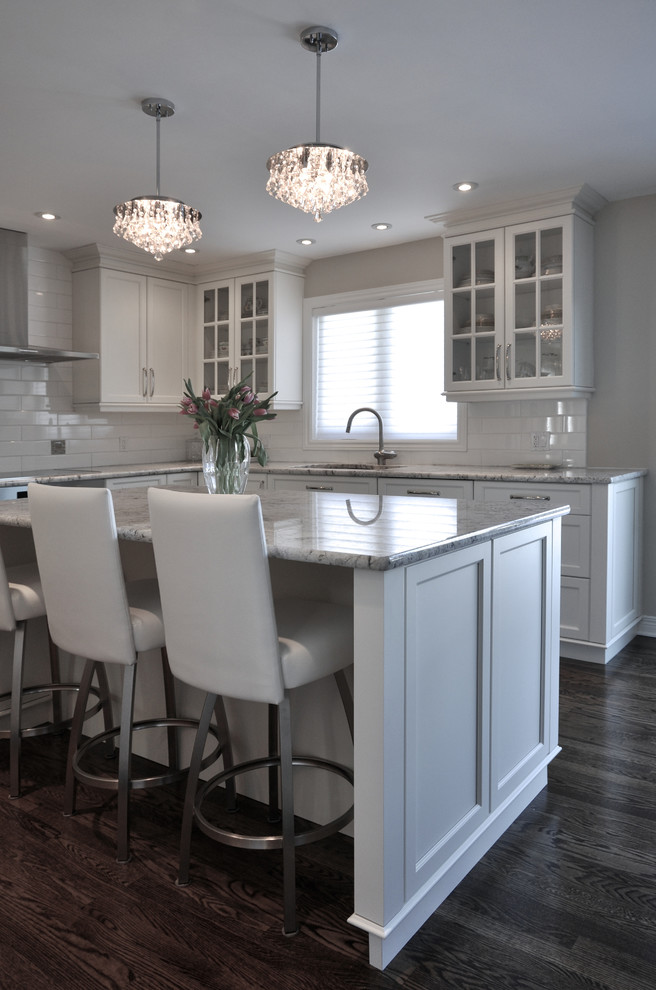 Design ideas for a large transitional u-shaped eat-in kitchen in Ottawa with an undermount sink, recessed-panel cabinets, white cabinets, granite benchtops, white splashback, ceramic splashback, stainless steel appliances, dark hardwood floors and with island.