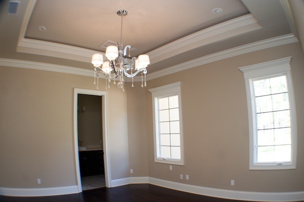 Photo of a large traditional master bedroom in Atlanta with beige walls and dark hardwood floors.