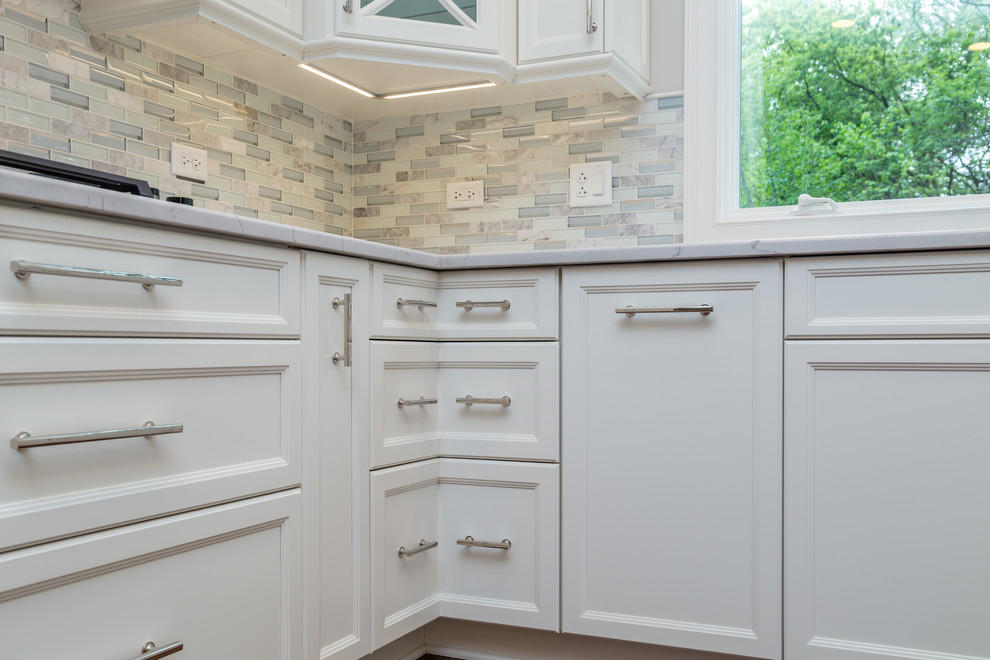 Huge elegant u-shaped medium tone wood floor and brown floor eat-in kitchen photo in Chicago with an undermount sink, recessed-panel cabinets, white cabinets, quartzite countertops, gray backsplash, ceramic backsplash, an island and white countertops
