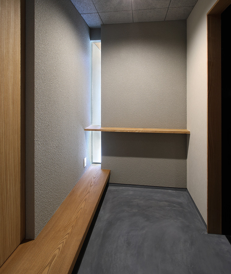 На фото: узкая прихожая среднего размера в стиле модернизм с серыми стенами, черной входной дверью и серым полом с