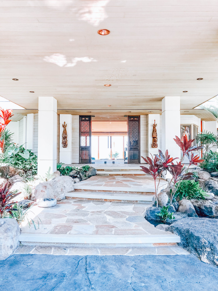 Expansive tropical foyer in Hawaii with white walls, a double front door, a glass front door, multi-coloured floor and wood.