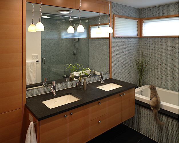 Inspiration for a mid-sized contemporary master bathroom in Seattle with an undermount sink, flat-panel cabinets, medium wood cabinets, granite benchtops, a drop-in tub, a two-piece toilet, multi-coloured tile, glass tile, beige walls, porcelain floors and an alcove shower.