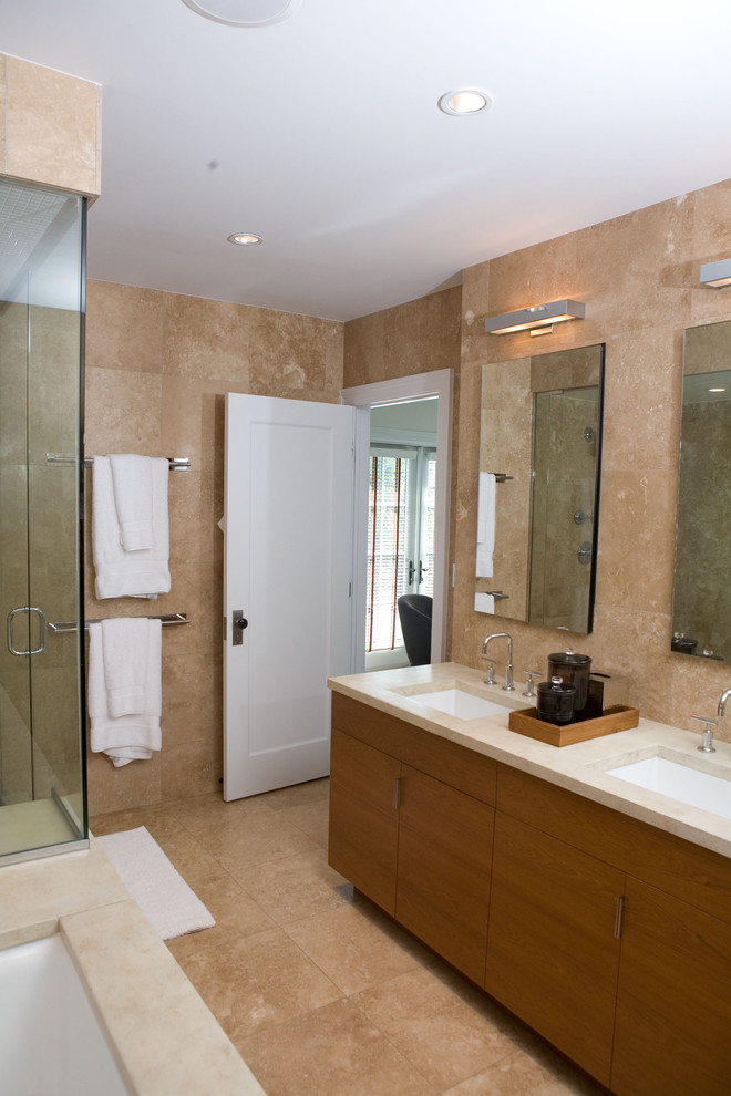 Photo of a mid-sized traditional master bathroom in Chicago with flat-panel cabinets, medium wood cabinets, a drop-in tub, a double shower, a one-piece toilet, beige tile, beige walls, travertine floors, an undermount sink, engineered quartz benchtops and travertine.