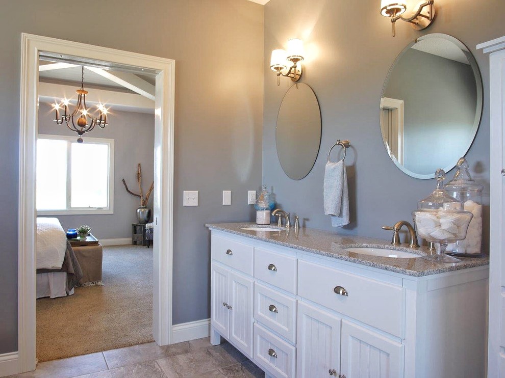 This is an example of a large country master bathroom in Indianapolis with an undermount sink, white cabinets, granite benchtops, a drop-in tub, a corner shower, a one-piece toilet, multi-coloured tile, stone tile and grey walls.