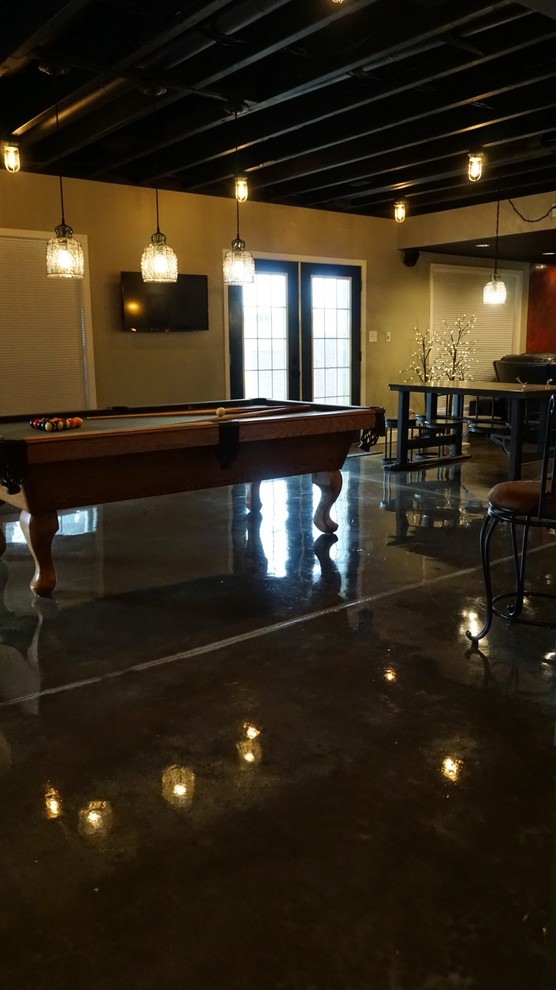 This is an example of a large modern walk-out basement in Louisville with grey walls, concrete floors and black floor.