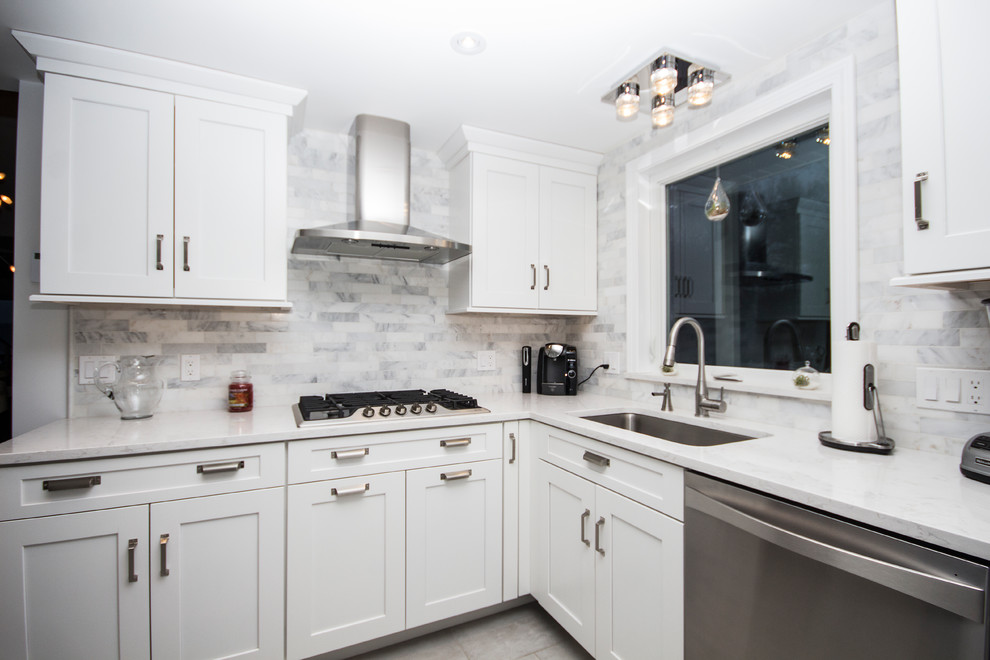 Photo of a mid-sized modern u-shaped eat-in kitchen in Boston with an undermount sink, shaker cabinets, white cabinets, quartz benchtops, white splashback, marble splashback, stainless steel appliances, porcelain floors and with island.
