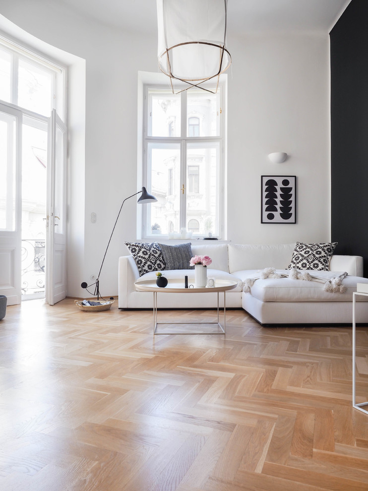 Inspiration for a mid-sized scandinavian open concept family room in Hanover with white walls and light hardwood floors.